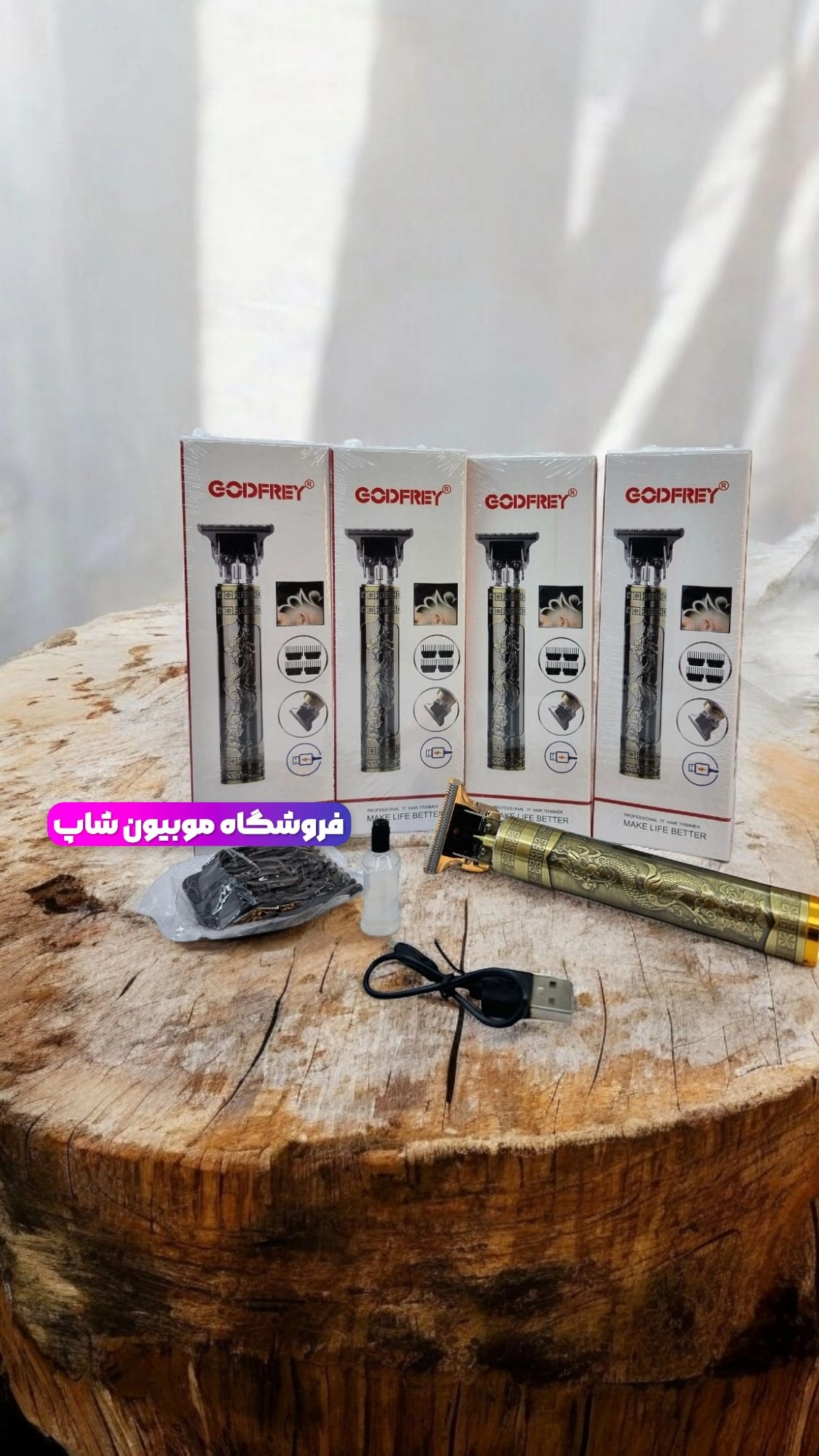 چهار عدد خط زن گود فری به همراه یک عدد ماشین اصلاح، کابل شارژ، روغن، سری ماشین روی یک میز گرد چوبی قرار دارد.